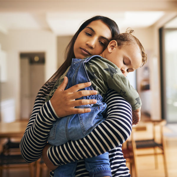 mother carrying sleeping child