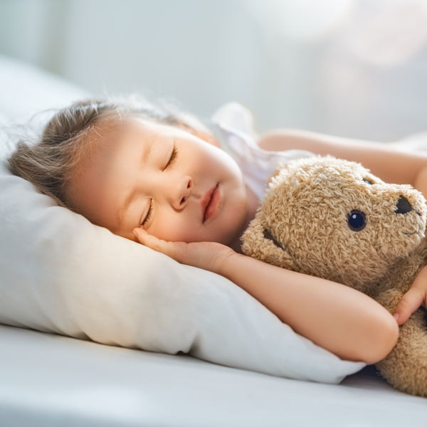 child sleeping with teddy bear