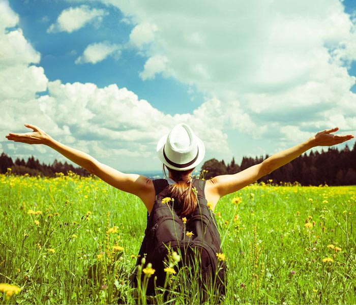 person standing in field on nice day with arms wide open